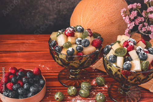 Melon on wooden table with black background