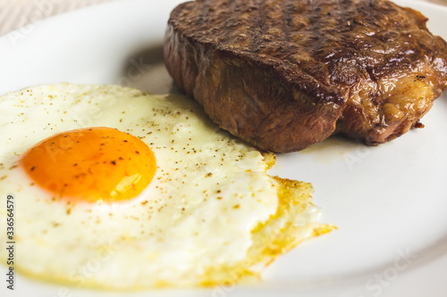 fried egg and steak on white plate
