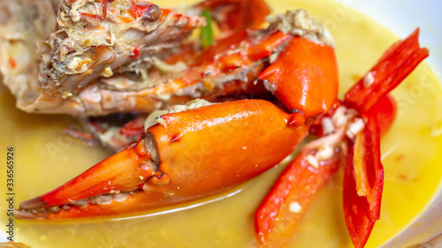 Indonesia crab curry garnished with red chili. Focus on the big claw photo