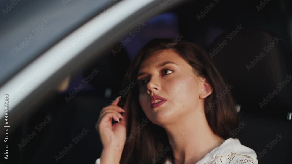 Pretty brunette applying mascara to the car front mirror and smiling Pretty brunette applying mascara to the car front mirror and smiling