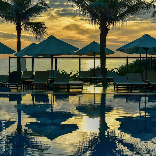 Reflection of palm trees and sky in swimming pool