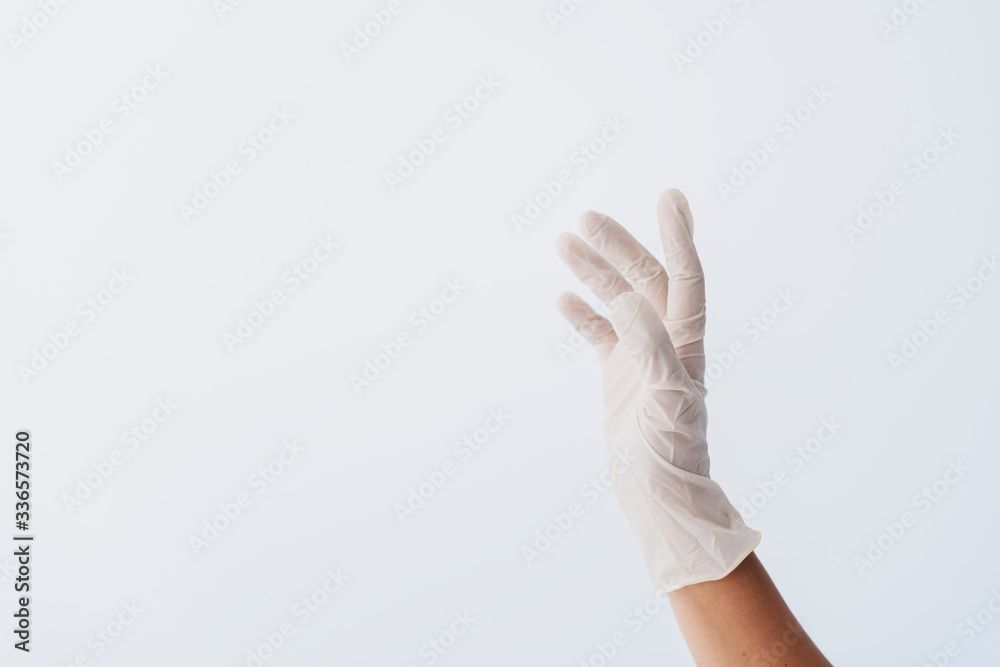 Hand wearing a white latex glove to prevent coronavirus contamination Hand wearing a white latex glove to prevent coronavirus contamination