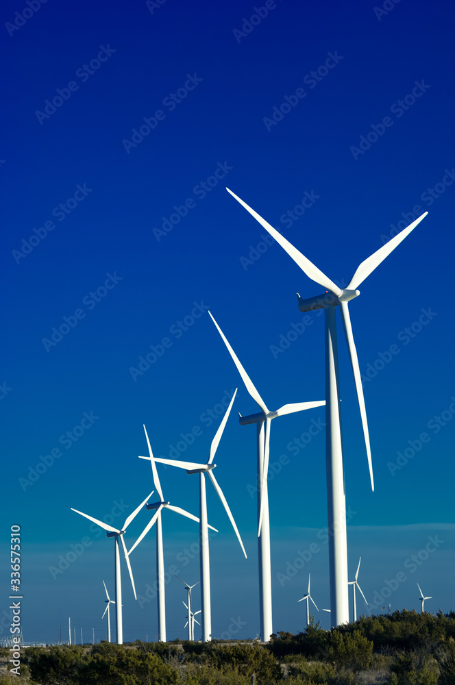 A group of wind turbines with blue sky background A group of wind turbines with blue sky background