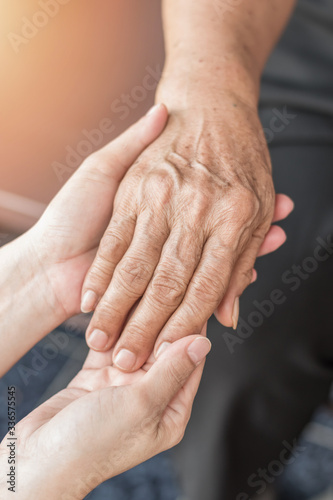 Fototapeta Naklejka Na Ścianę i Meble -  Parkinson disease patient, Alzheimer elderly senior, Arthritis person's hand in support of nursing family caregiver care for disability awareness day, National care givers month, ageing society