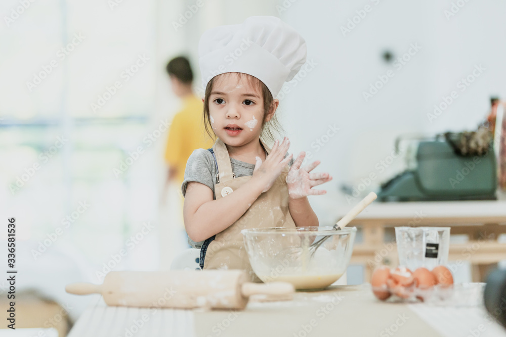Sweet little cute girl is learning how to make a cake, in the home kitchen, Family concept, Vintage color tone. Sweet little cute girl is learning how to make a cake, in the home kitchen, Family concept, Vintage color tone.