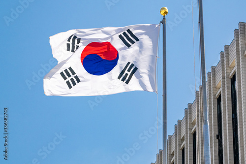 South Korean flag waving in the wind atop a government building on a sunny day - Seoul, South Korea photo