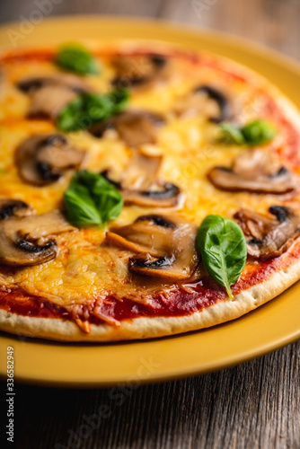 Freshly making pizza with mushrooms served on the rustic background. Selective focus. Shallow depth of field.