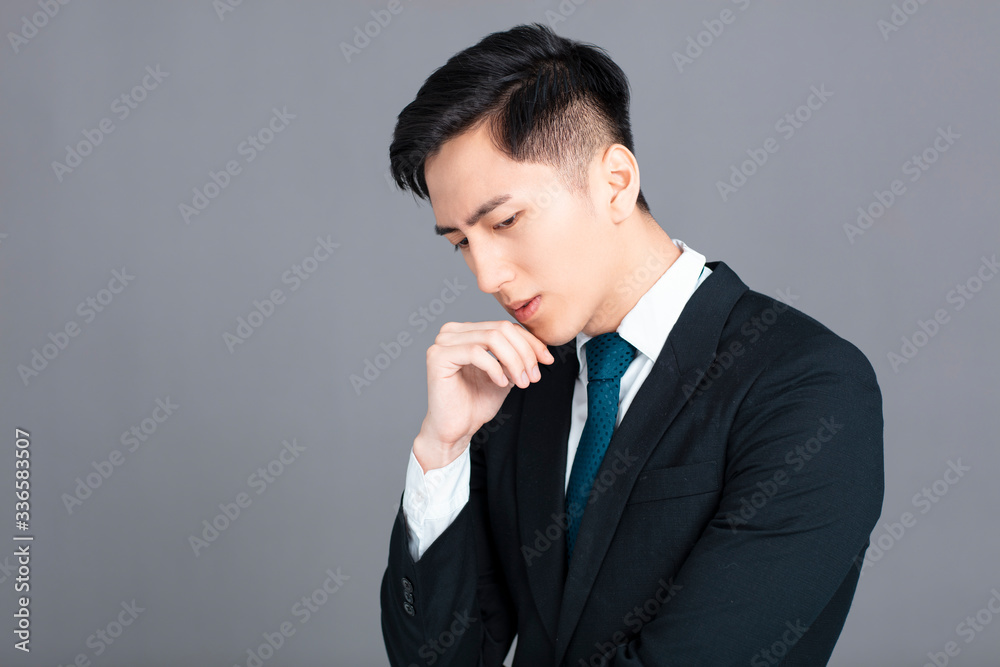 Stressed and confused young business man on gray background Stressed and confused young business man on gray background
