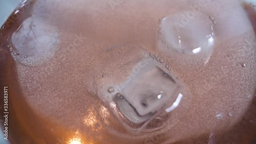 Close-up of three ice cubes in glass on slow motion photo