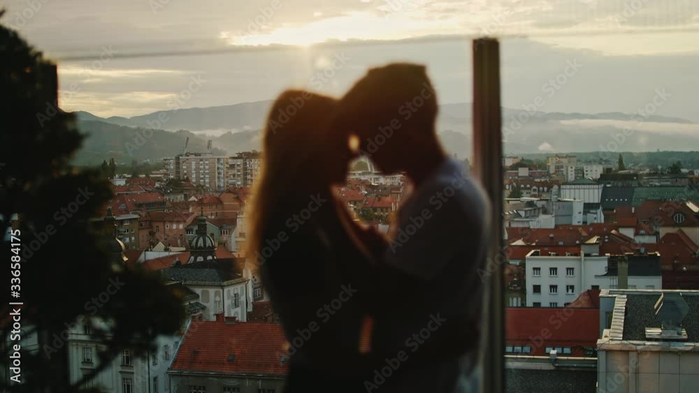Couple leaning in for a kiss at the golden hour