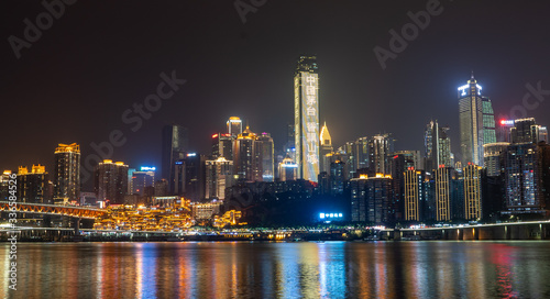 Night neon ight pano view of historic traditional architecture in Hongya Dong cave by Jialing river in Chongqing  China