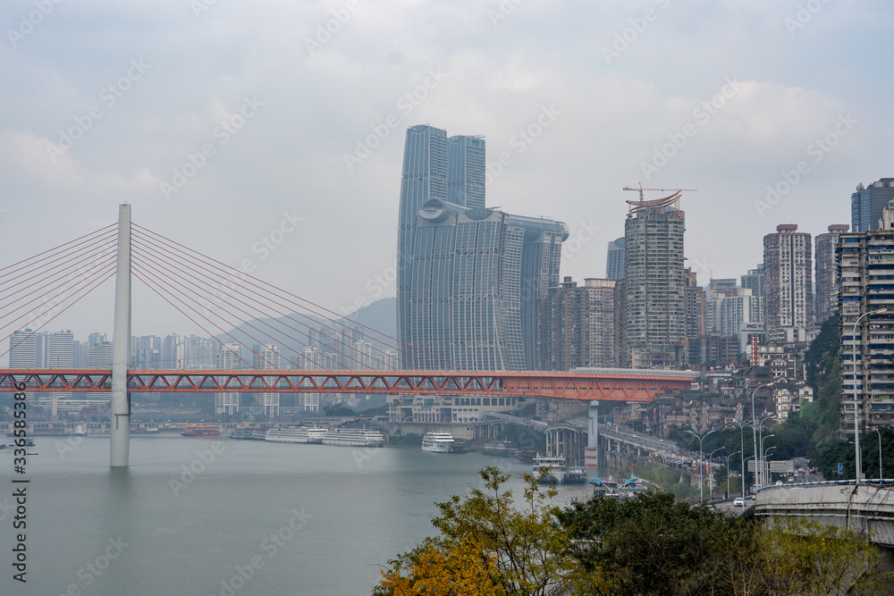 Qian si men suspension bridge with sky scrapers in background by Yangtze river in Chongqing, China