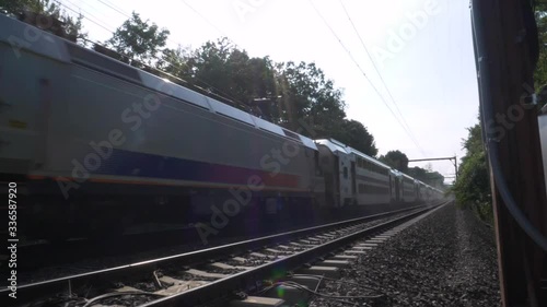 SLOW MOTION: Front of commuter train, close up, as it passes by on the train tracks photo