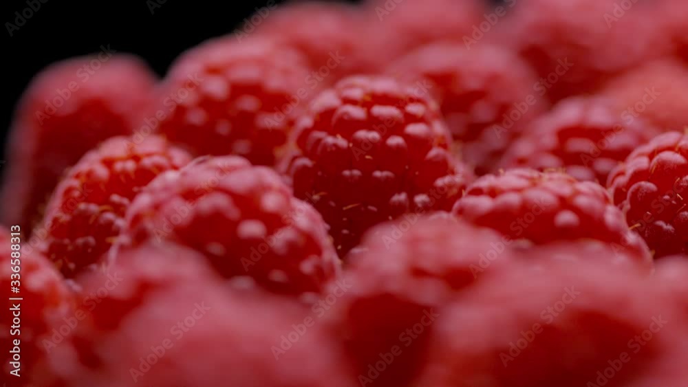 Endless raspberries rotating on a black background