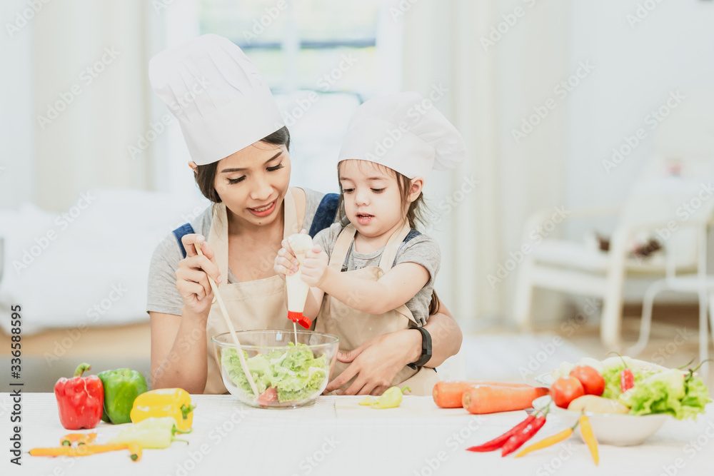 Happy family mom teaching cute girl preparing and cooking healthy salad for the first time. first lesson and healthy lifestyle concept. Happy family mom teaching cute girl preparing and cooking healthy salad for the first time. first lesson and healthy lifestyle concept.