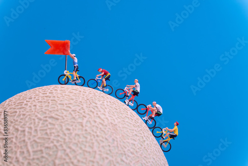Miniature toys - road cyclist approaching finish line, celebration concept. photo