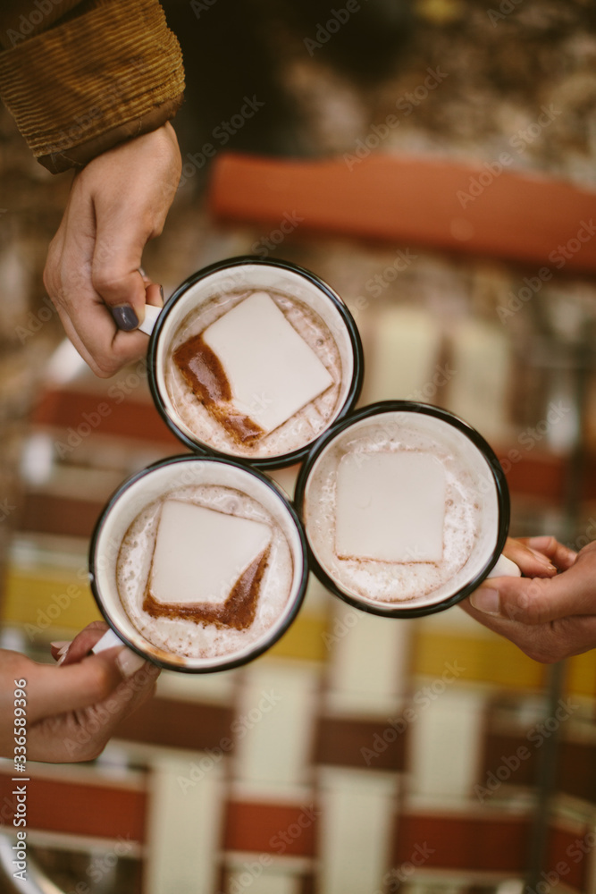 overhead shot of people holding mugs of hot chocolate outdoors