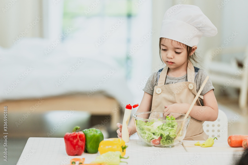Sweet little cute girl is learning how to make a salad, in the home kitchen, Family concept, Vintage color tone. Sweet little cute girl is learning how to make a salad, in the home kitchen, Family concept, Vintage color tone.