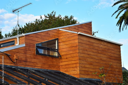 Modern cedar house with complex roof arrangement and no overhangs.