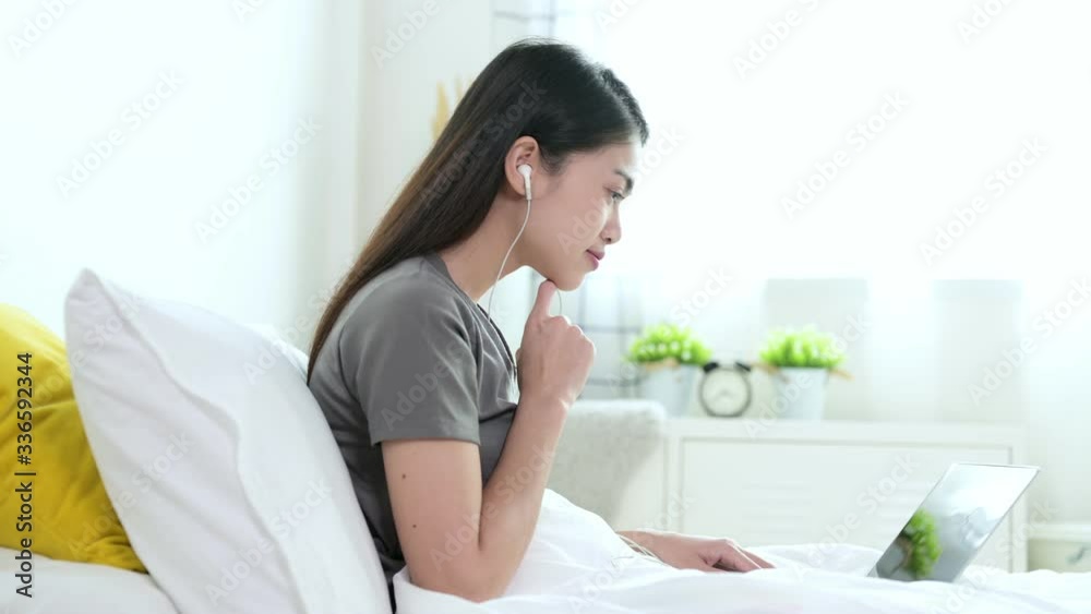 Beautiful young asian woman in grey T-shirt are video calling by laptop with her friend, family or boyfriend for social distancing policy. Self quarantine, coronavirus, work from home concept Beautiful young asian woman in grey T-shirt are video calling by laptop with her friend, family or boyfriend for social distancing policy. Self quarantine, coronavirus, work from home concept