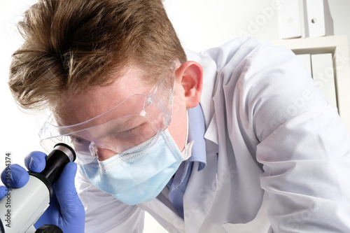 doctor looking through a microscope. scientist looking through a microscope