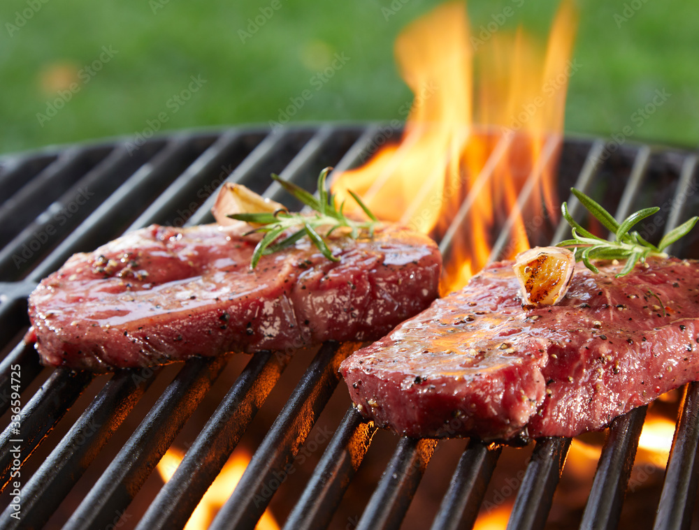 Beef steak seasoned with herbs on burning grill Beef steak seasoned with herbs on burning grill