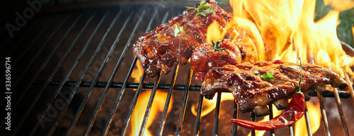 Fotografiet Marinated spicy pork ribs grilling on a bbq