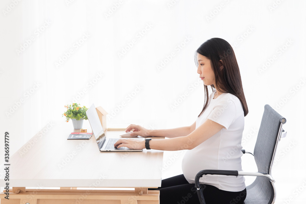 Yong Asian pregnant woman working at home or office, planning about health checking schedule, flexible working time or financial for home loan.