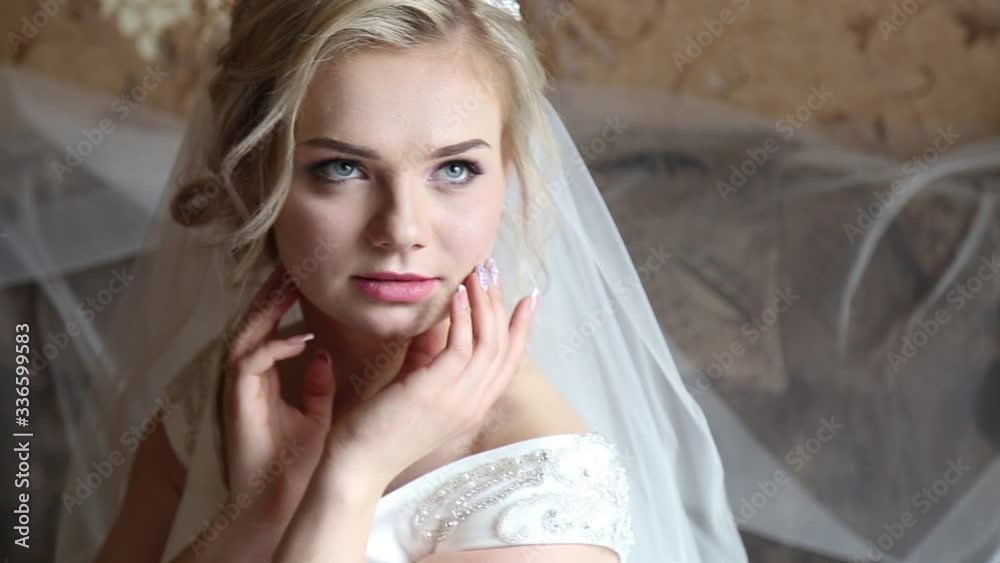 Adorable young bride is getting ready in the morning at home. The bride getting ready for the wedding is dressed in a white dress Adorable young bride is getting ready in the morning at home. The bride getting ready for the wedding is dressed in a white dress