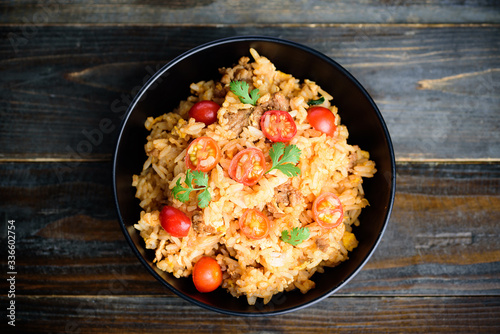 Fried rice with minced pork and tomato in a bowl on wooden background, Asian food, Top view