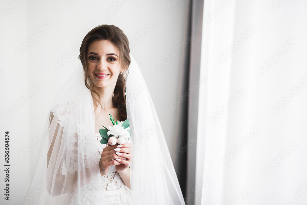 Luxury bride in white dress posing while preparing for the wedding ceremony Luxury bride in white dress posing while preparing for the wedding ceremony