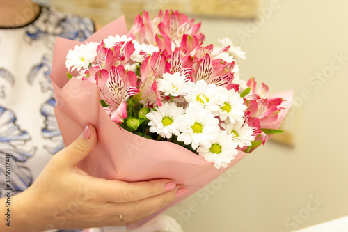 Fototapeta Naklejka Na Ścianę i Meble -  Blooming beautiful pink white flowers is in the woman hands close up. Romantic and celebration concept. Background horizontal format