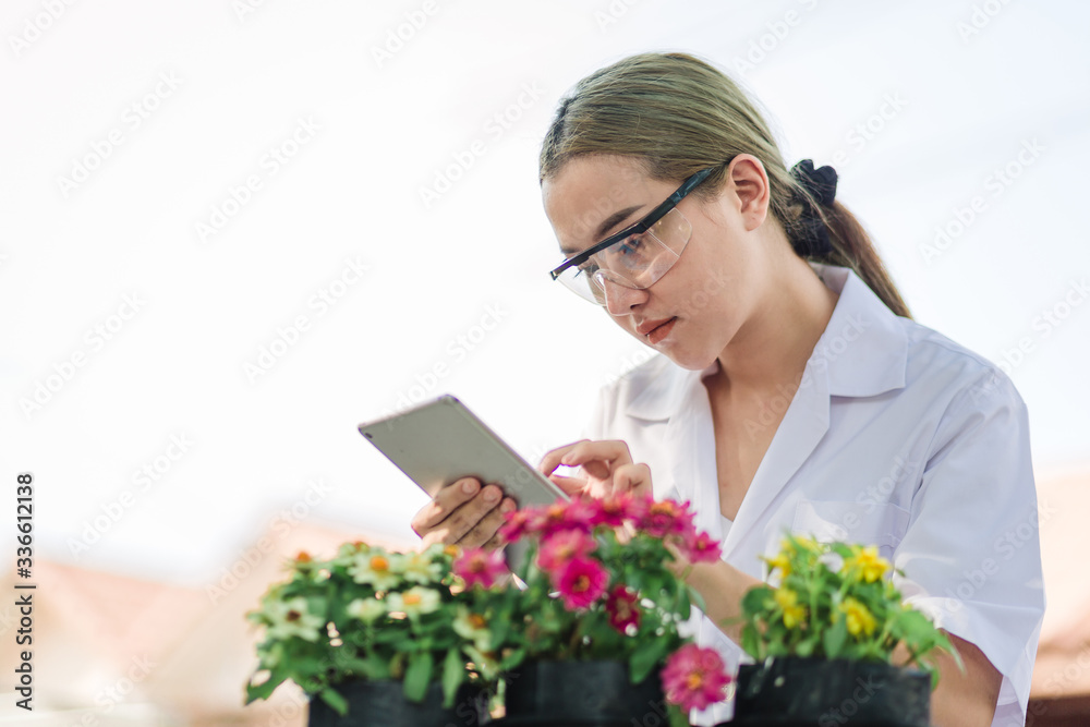 Young biologist holding a pot with a seedling and examining the growth beside Plant protection concept Young biologist holding a pot with a seedling and examining the growth beside Plant protection concept