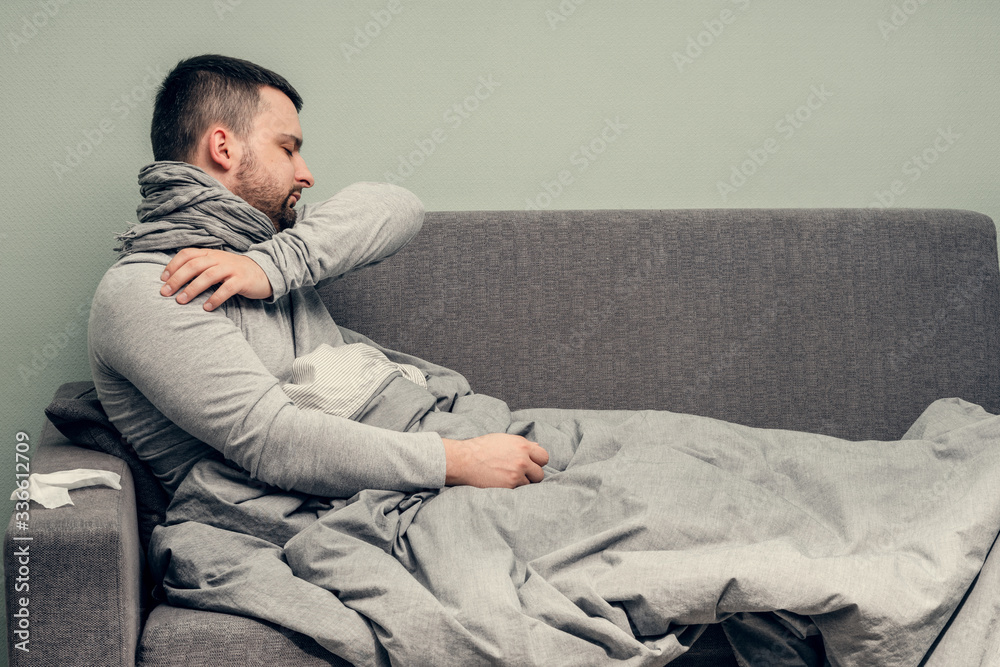 Disease. Cheer at home. A young man is sick, is treated at home. Blows her nose into a napkin, runny nose. Infection, epidemic, bacillus carrier.