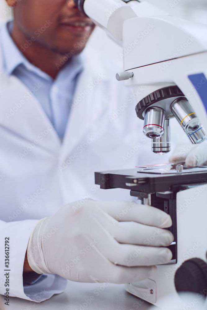 Smart biologist working on a cutting-edge microscope Smart biologist working on a cutting-edge microscope