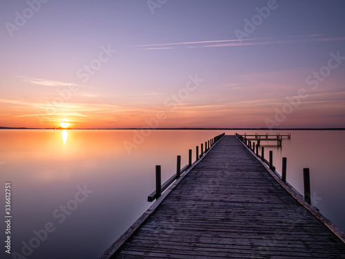 Fototapeta Naklejka Na Ścianę i Meble -  Steg im Wasser beim Sonnenuntergang