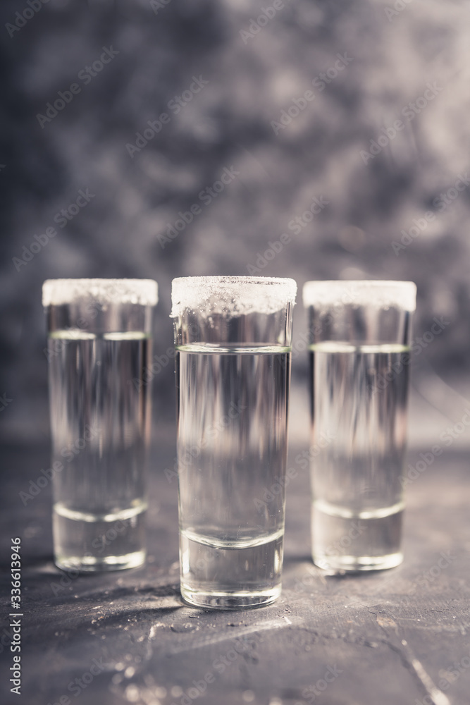 Tequila shots on the dark rustic background. Selective focus. Shallow depth of field.