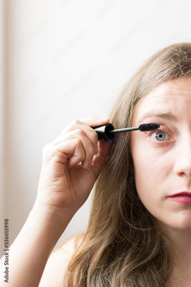 Young woman portrait putting on black mascara Young woman portrait putting on black mascara