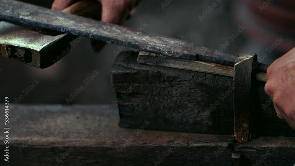 the blacksmith is using a grinding wheel to grind the knife. the blacksmith is using a grinding wheel to grind the knife.