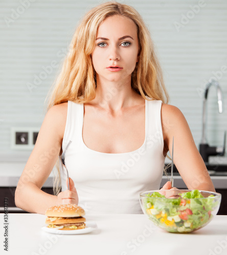 Woman chooses between a healthy and unhealthy food