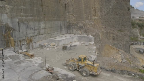 Digger working in a black granite quarry