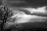 black and white image of  sunbeams in the clouds illuminate the Telesina Valley, Benevento, Campania, Italy