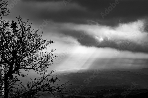 black and white image of sunbeams in the clouds illuminate the Telesina Valley, Benevento, Campania, Italy