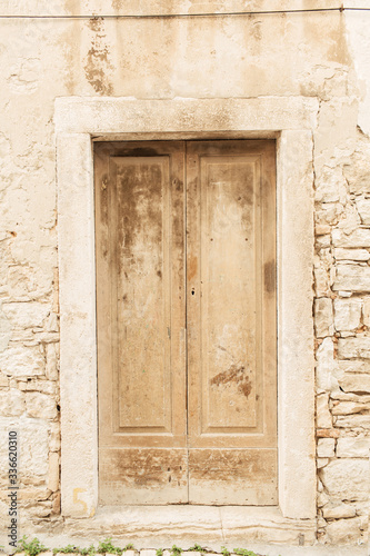 Dubrovnik, Croatia, 2019. Stone building with old vintage beige wooden door. Travel concept. © Floral Deco