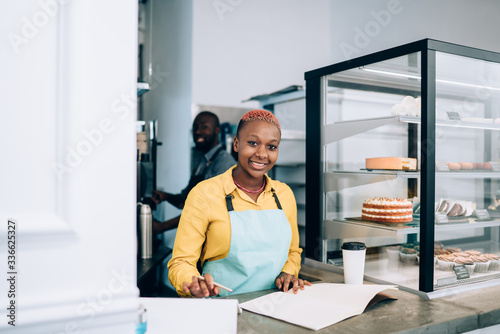 Bright waitress writing down cafe assortment