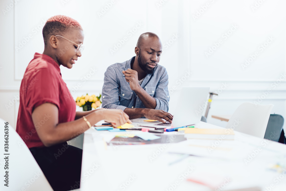 Black coworkers working at table with laptop Black coworkers working at table with laptop