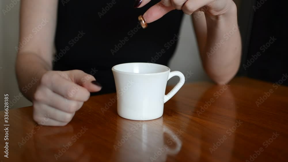 Women in a cafe with a cup of coffee removes a wedding ring from a finger, throws it into a cup and leaves Women in a cafe with a cup of coffee removes a wedding ring from a finger, throws it into a cup and leaves