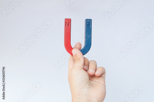 hand holding a magnet isolated on white background
