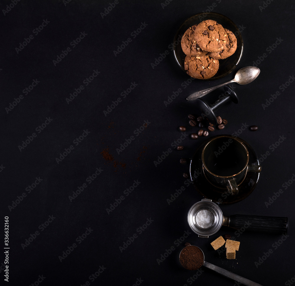 Coffee, cookies and utensils for coffee maker on black background with copy space for text