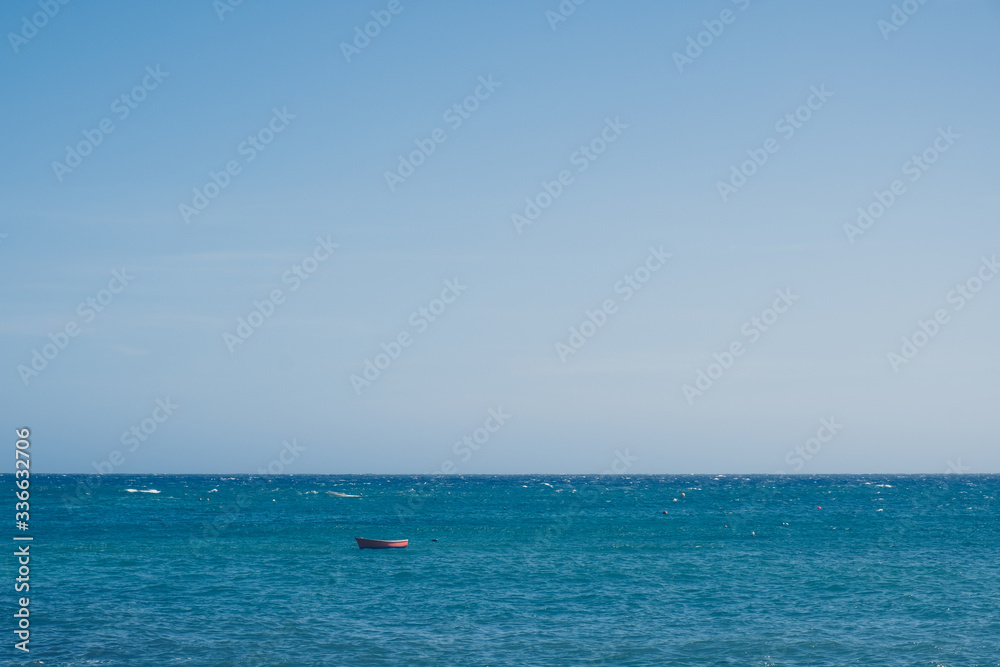 Wooden small boat in the sea landscape with endless horizon